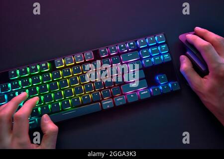 Personal point of view on player hands using color backlighted keyboard and mouse. Professional computer game playing, esport business and online worl Stock Photo