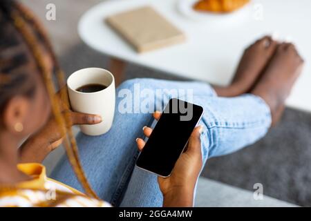 Top view of black woman using cellphone with blank screen Stock Photo