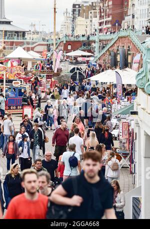 Brighton UK 30th August 2021 -  Crowds visit Brighton seafront despite the cool and overcast August bank holiday weather .  : Credit Simon Dack / Alamy Live News Stock Photo