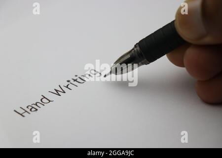 Hand writing being written on plane sheet of paper by black pen, Concept showing fonts of handwriting Stock Photo