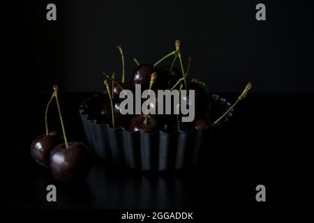 Juicy black cherries in a fluted flan dish Stock Photo