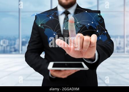 Man In Uniform Standing Holding Tablet And Virtually Typing With Pen. Business Man Carrying Pad Typing And Displaying New Futuristic Technologies. Stock Photo