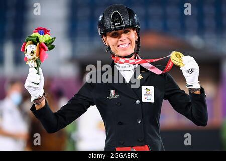 Belgian jockey Michele George celebrates on the podium after