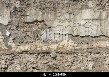 cracked white concrete wall under direct sun light full frame