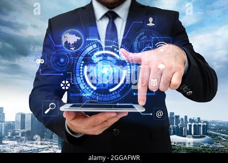 Man In Uniform Standing Holding Tablet And Virtually Tapping Screen. Business Man Carrying Pad Typing And Displaying New Futuristic Technologies. Stock Photo