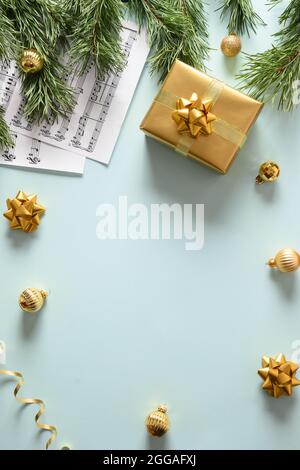 Music sheets for Christmas Carols and sings decorated golden balls on blue background. View from above. Vertical format. Stock Photo