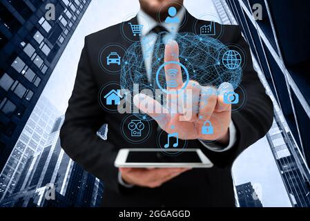 Man In Uniform Standing Holding Tablet And Virtually Tapping Screen. Business Man Carrying Pad Typing And Displaying New Futuristic Technologies. Stock Photo