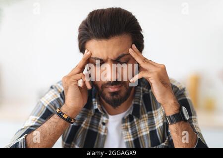 Closeup portrait of tired arab man suffering from headache Stock Photo