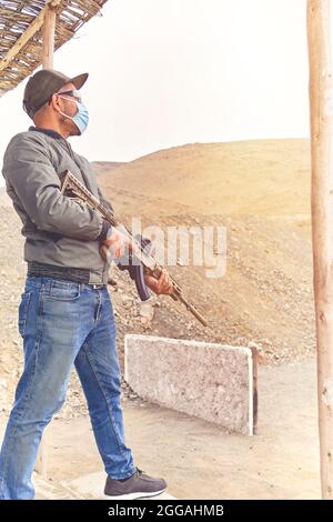 Men practicing shooting with a assault rifle at target. Selective Focus Stock Photo