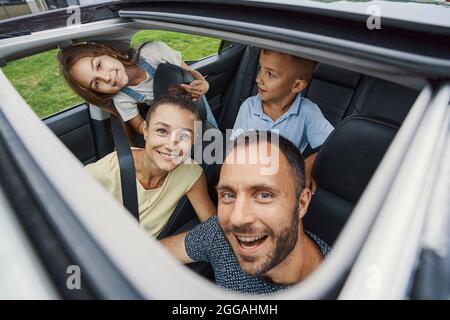 Family of four feeling excited before the road trip Stock Photo