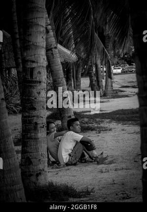 SUBIC, PHILIPPINES - Aug 01, 2017: A gray scale view of a Filipino couple dating sitting at the beach of SMBA in Olongapo City Zambales. Stock Photo