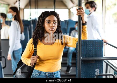 Beautiful focused black woman standing in bus Stock Photo
