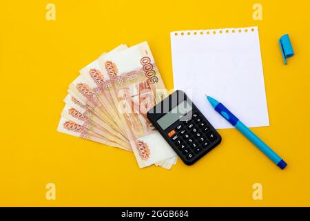 Russian banknotes with a notebook and a pen on a yellow background. business concept Stock Photo