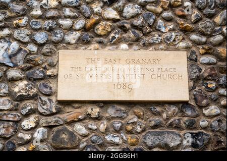 A flint wall with a plaque denoting The East Granary where the first public meeting place of St.Marys Baptist church Stock Photo