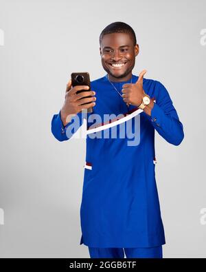 excited young african man doing a video call doing a thumbs up to the person he's calling Stock Photo