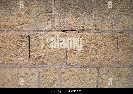 detail of a wall of ochre, brown and beige masonry and mortar stones Stock Photo