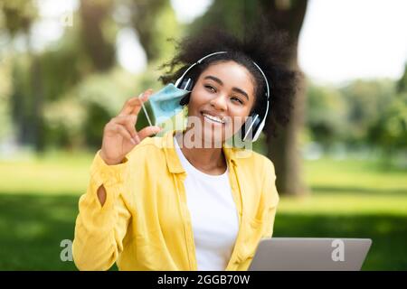 Joyful African American Student Girl Taking Off Face Mask Outdoor Stock Photo