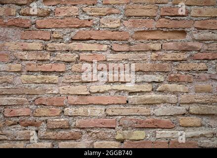 detail of a wall of red and brown deteriorated bricks Stock Photo