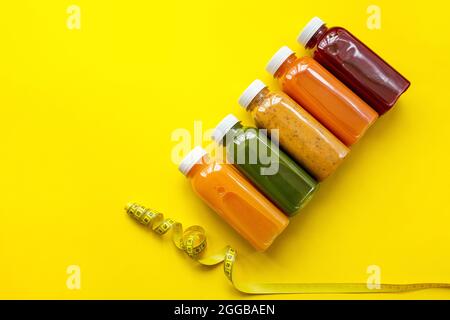 Fresh juices or cocktails of fruits and vegetables in bottles on a yellow background. The concept of a healthy diet or diet. Fresh organic ingredients Stock Photo