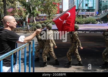 A man is seen waving the Turkish flag during the military parade.Victory Day is an official and national holiday celebrated on August 30 every year in Turkey and the Turkish Republic of Northern Cyprus to commemorate the Great Offensive, which ended in victory under Ataturk's command in Dumlup?nar on August 30, 1922. On the 99th anniversary of the victory, the Turkish army gathered in front of the Turkish Grand National Assembly (TBMM) and organized a march to Ulus, where the former Turkish Grand National Assembly was located. Stock Photo