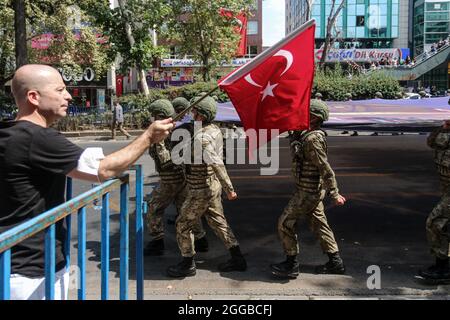 A man is seen waving the Turkish flag during the military parade.Victory Day is an official and national holiday celebrated on August 30 every year in Turkey and the Turkish Republic of Northern Cyprus to commemorate the Great Offensive, which ended in victory under Ataturk's command in Dumlup?nar on August 30, 1922. On the 99th anniversary of the victory, the Turkish army gathered in front of the Turkish Grand National Assembly (TBMM) and organized a march to Ulus, where the former Turkish Grand National Assembly was located. (Photo by Tunahan Turhan/SOPA Images/Sipa USA) Stock Photo