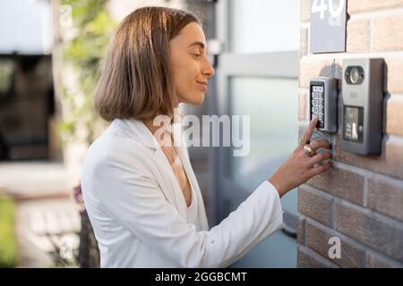 Woman entering code on a keyboard to access a door Stock Photo