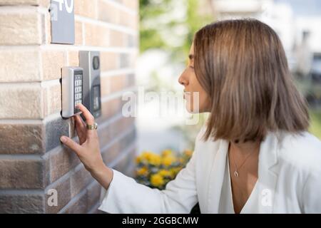 Woman entering code on a keyboard to access a door Stock Photo