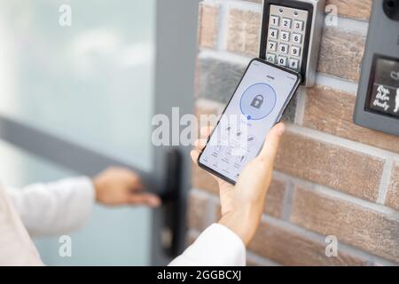 Opening door with a smart phone and keyboard on the wall Stock Photo