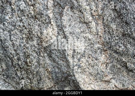 Untreated natural texture of gray granite close-up. Abstract background, texture, pattern, wallpaper. Stock Photo