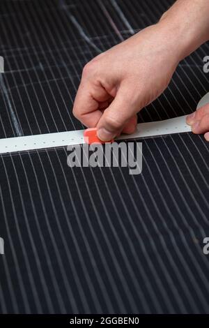 Tailor carefully measuring cloth while making a men suit. designer workplace in atelier Stock Photo
