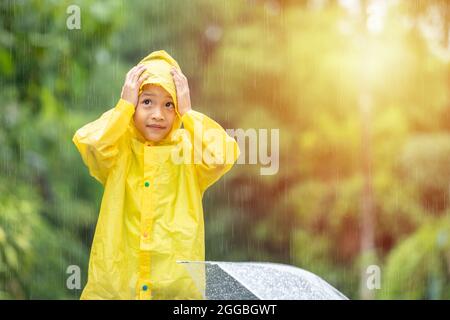 Boy wearing yellow rain coat smiling while fishing Stock Photo - Alamy