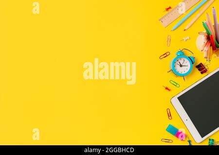 Back to school, online study, distantly learning class concept. Creative student desk with tablet pc and colorful modern school supplies on yellow background. Top view Flatlay. Copy space Stock Photo