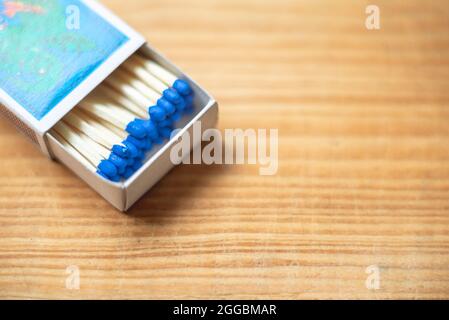 Wooden safety matchsticks stacked in cardboard matchbox on wooden background.Box of matches.Wooden table.copy space.Open box of matches.closeup. Stock Photo