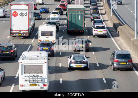 Section of M25 motorway in Longford near Heathrow Airport, UK, busy with traffic on a Bank Holiday August summer weekend. Campervan and caravan Stock Photo