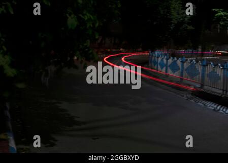 Car Light trails on a city street in a dark black night. Photo is taken with long exposer. Stock Photo