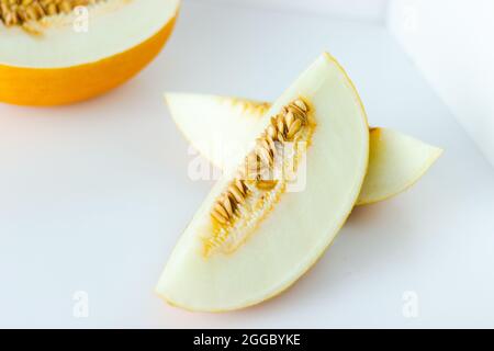 Close up of honeydew melon slices with seeds isolated on white background Stock Photo