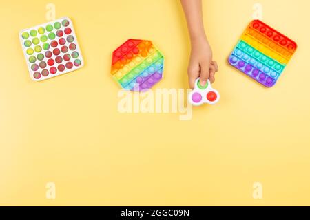 Teenager hand holding trendy antistress gadget fidget spinner. Man playing  with green spinner outdoors on the bright bokeh sunlight rays. Shallow DOF  Stock Photo - Alamy