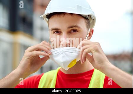Skilled serene young worker getting ready for work Stock Photo