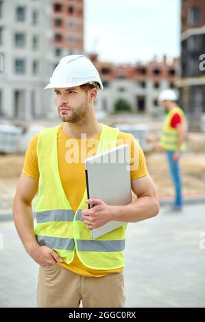 Attractive engineer in a protective helmet looking away Stock Photo