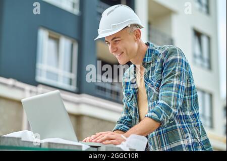 Focused building engineer using his gadget on the construction site Stock Photo