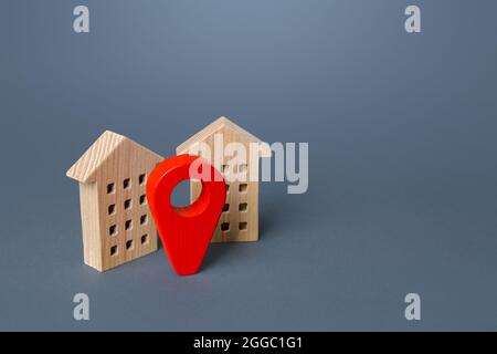 Red location pin and houses. Location concept, settlement. Tracking, internet of things. City navigation, orienteering. Search for housing options. In Stock Photo
