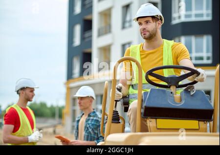 Serene construction worker and his two coworkers outdoors Stock Photo