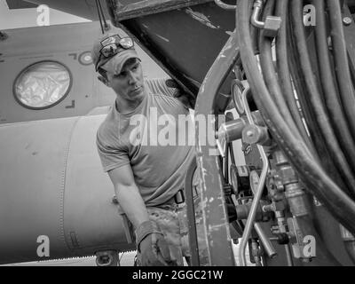 A Paratrooper assigned to the 82nd Combat Aviation Brigade, 82nd Airborne Division prepares a  CH-47 Chinook to load onto a U.S. Air Force C-17 Globemaster III at Hamid Karzai International Airport in Kabul, Afghanistan, August 28. The Chinook. is one of the pieces of equipment returning to the U.S. as the military mission in Afghanistan comes to an end. Stock Photo