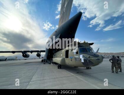 A CH-47 Chinook from the 82nd Combat Aviation Brigade, 82nd Airborne Division is loaded onto a U.S. Air Force C-17 Globemaster III at Hamid Karzai International Airport in Kabul, Afghanistan, August 28. The Chinook. is one of the pieces of equipment returning to the U.S. as the military mission in Afghanistan comes to an end. Stock Photo