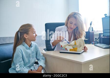 Patient looking at the auditory system demonstration model during the consultation Stock Photo