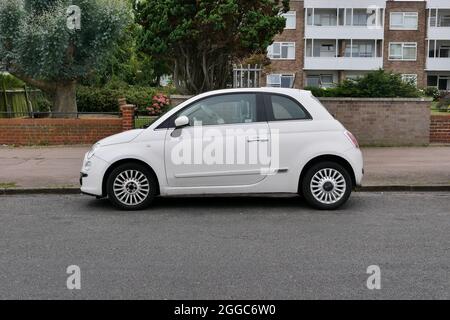 30 August 2021 - Essex, UK: White Fiat 500 parked in road in front of apartments Stock Photo