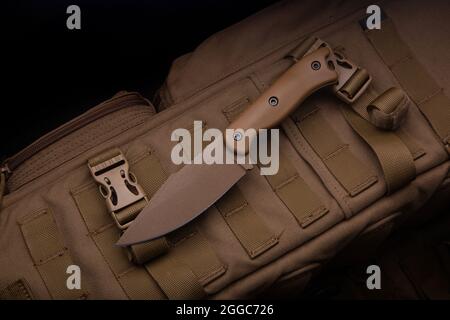 Premium Photo  A modern military knife and a plastic sheath for it edged  weapons lie on a military olivecolored backpack