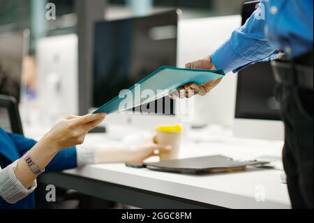 Two managers exchange documents in IT office Stock Photo