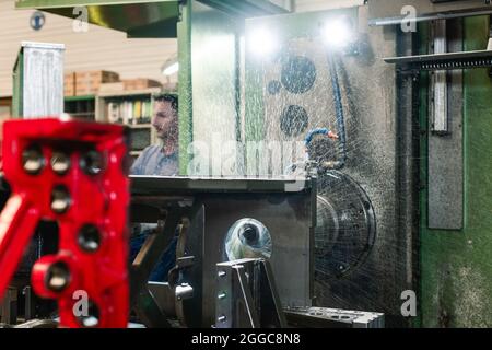 Worker operating industrial milling machine Stock Photo