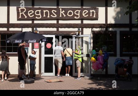 Gavle, Norrland Sweden - July 13, 2021: people standing in line for rides during pandemic times, text on sign: - Rainforest Stock Photo